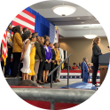 People standing on a stage with American flags in background